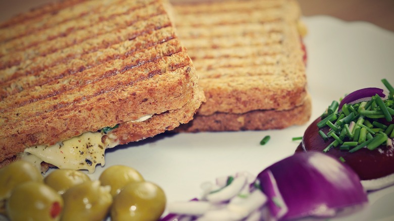 Grilled cheese with green olives and red onion