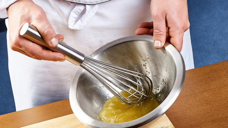 chef whisking gravy in bowl