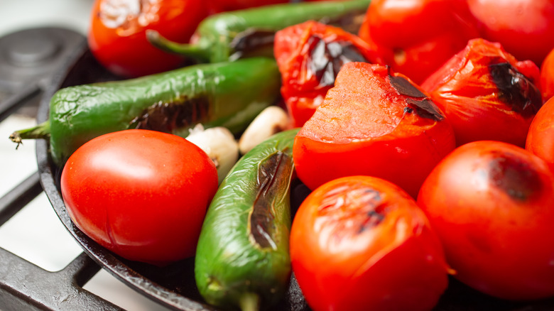 jalapenos, tomatoes and garlic roasting on a comal