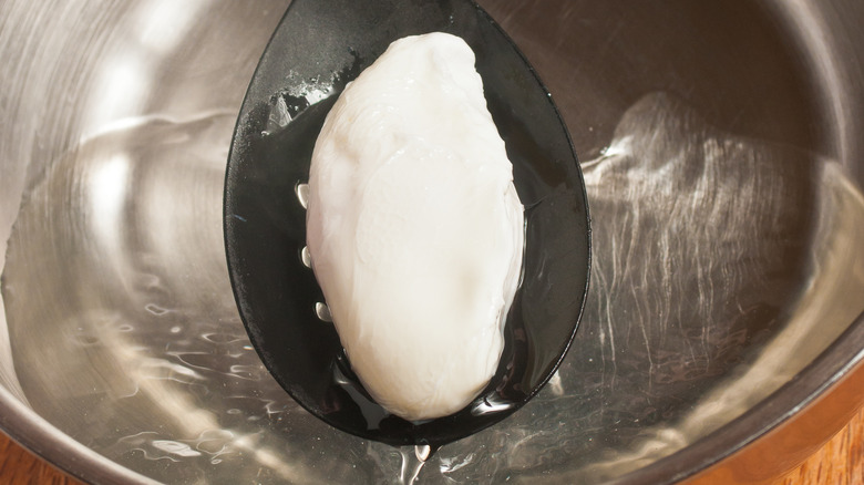 pulling poached egg out of vinegar water