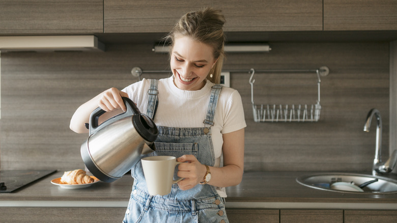 women pouring herself cup of coffee