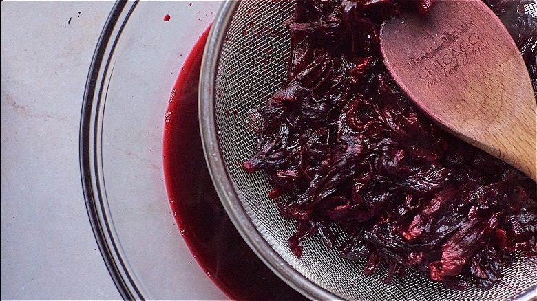 straining hibiscus into bowl