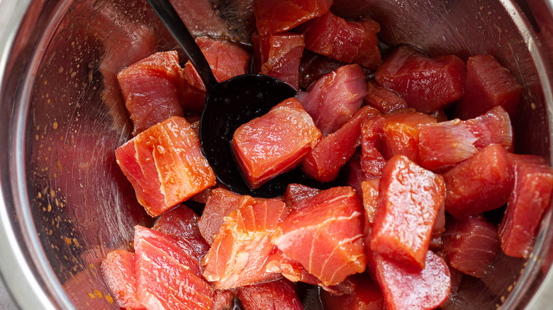 raw tuna cubes in bowl with marinade