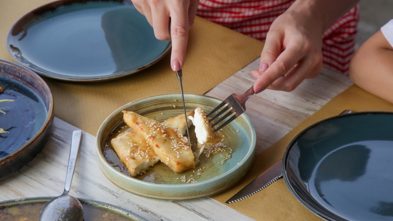 cutting fried feta with honey