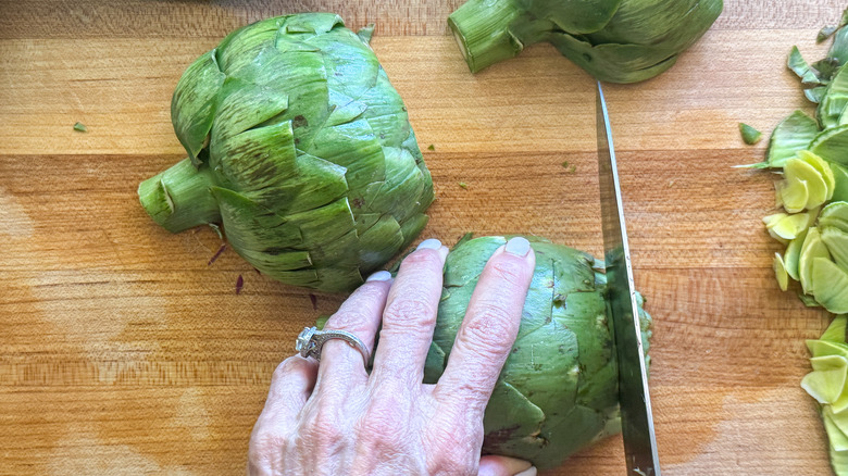 hand cutting the artichoke top