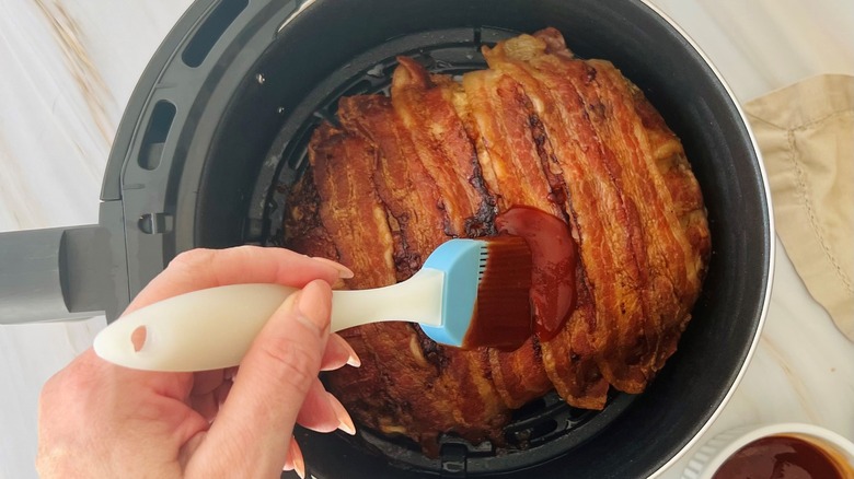 hand brushing sauce on meatloaf