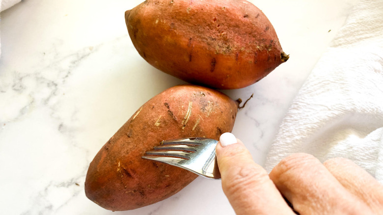 piercing sweet potatoes with fork 