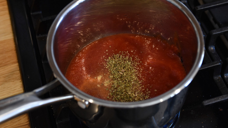 marinara and seasoning in pot