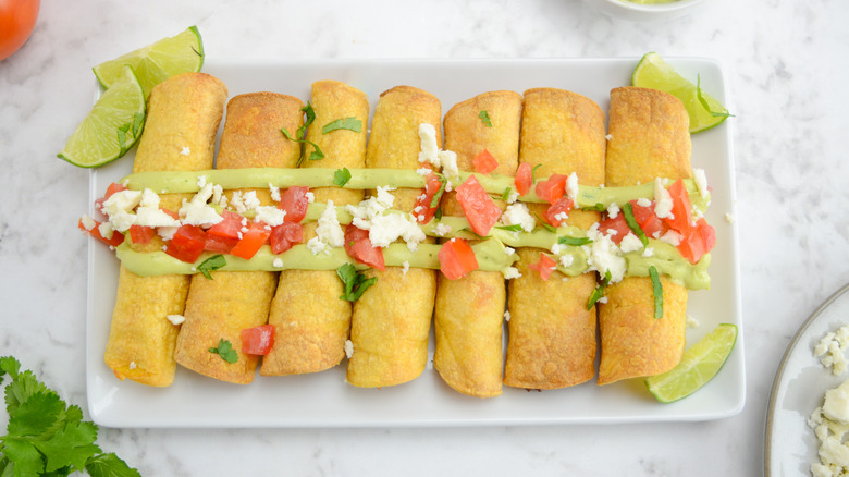 plate with garnished chicken taquitos