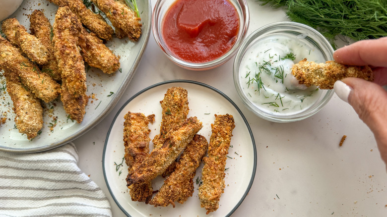 hand dipping into dill dip