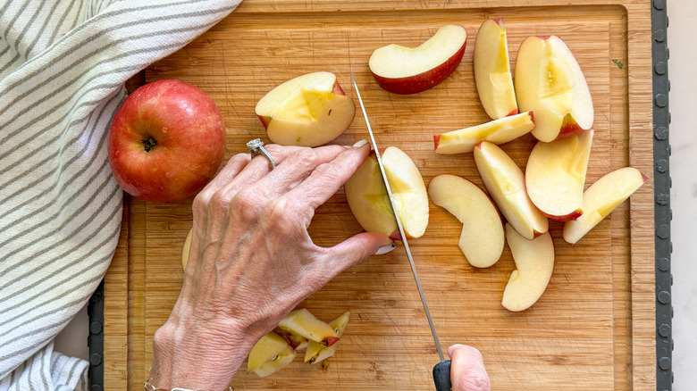 hands cutting apple into slices