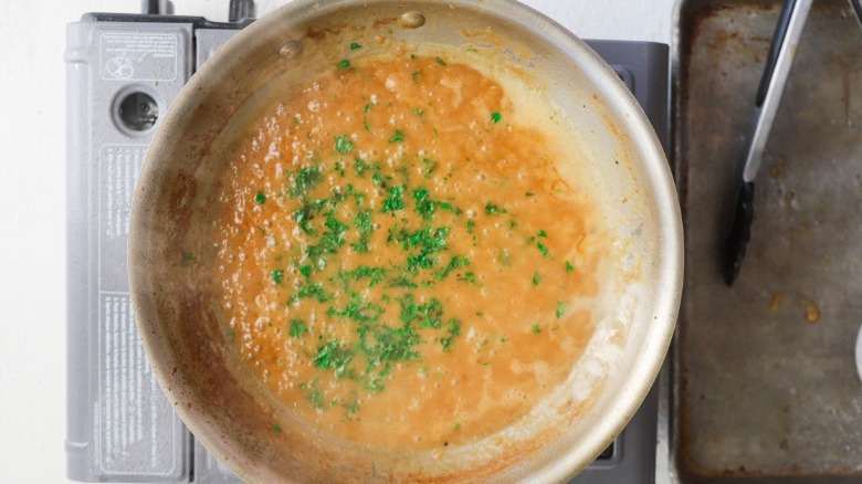 Adding fresh herbs to the sauce