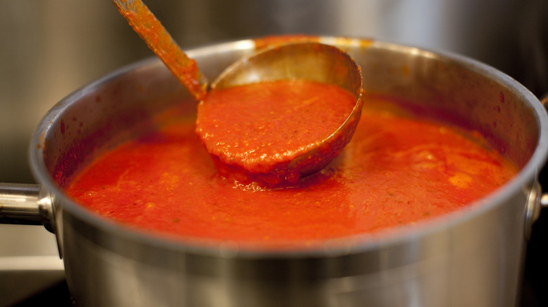 Pot of marinara sauce with a ladle