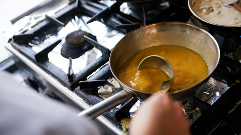 Person cooking gravy on a stove