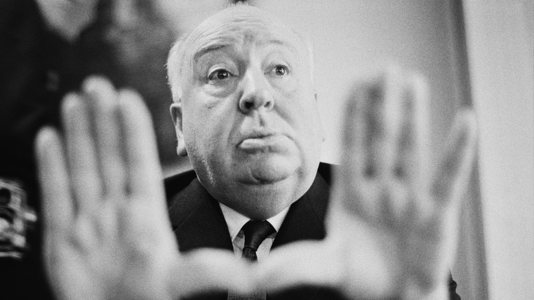 Alfred Hitchcock with hands up
