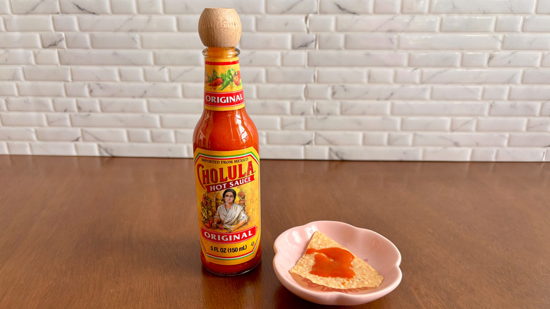 Cholula original hot sauce next to tortilla chip