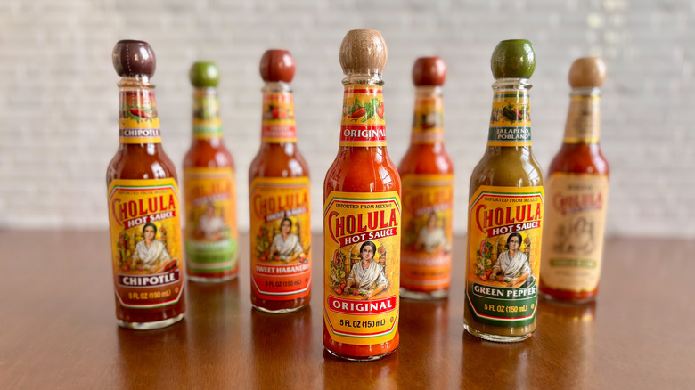 Various Cholula hot sauce bottles on table