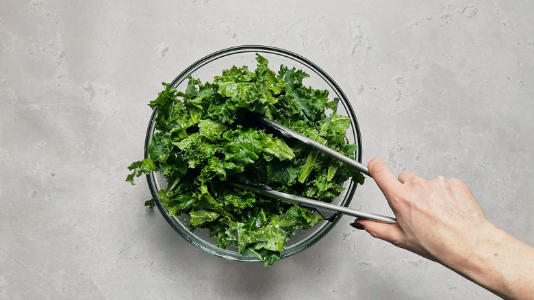 tossing kale in bowl