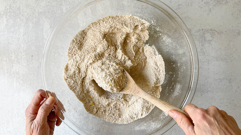 All-purpose and almond flour, baking powder and salt mixed by wooden spoon in mixing bowl