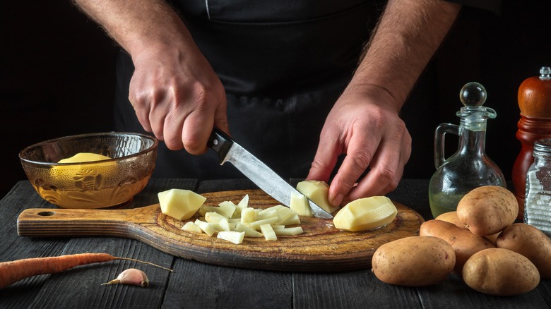 chef cutting potatoes