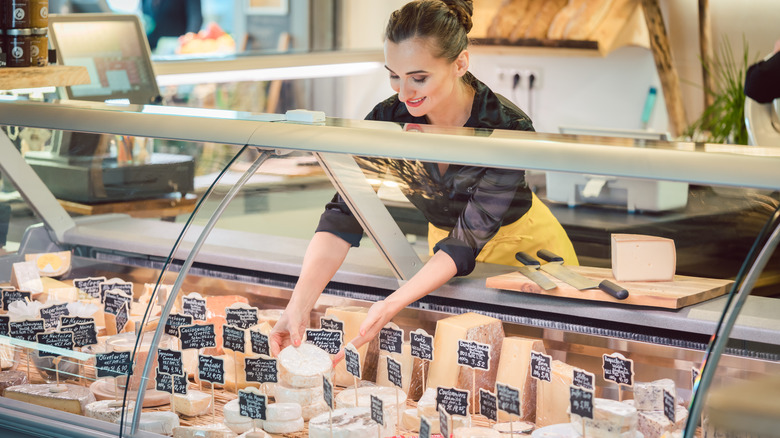 Woman working behind cheese counter