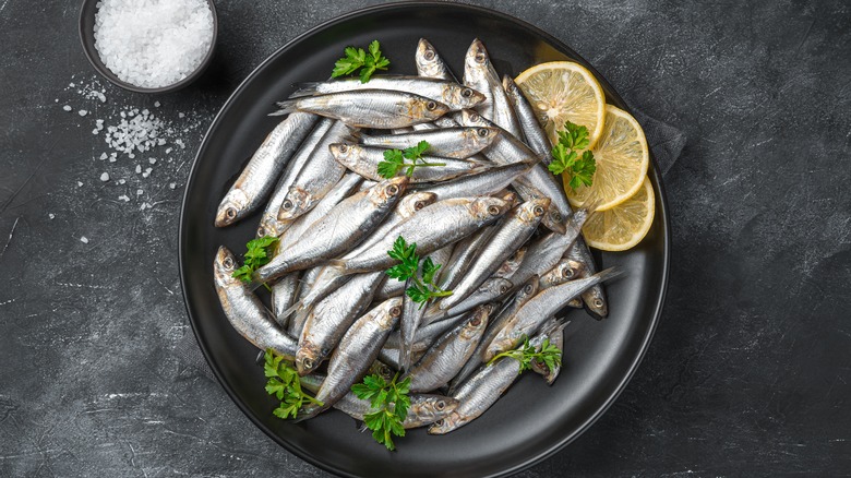 Sardines and lemons in black dish