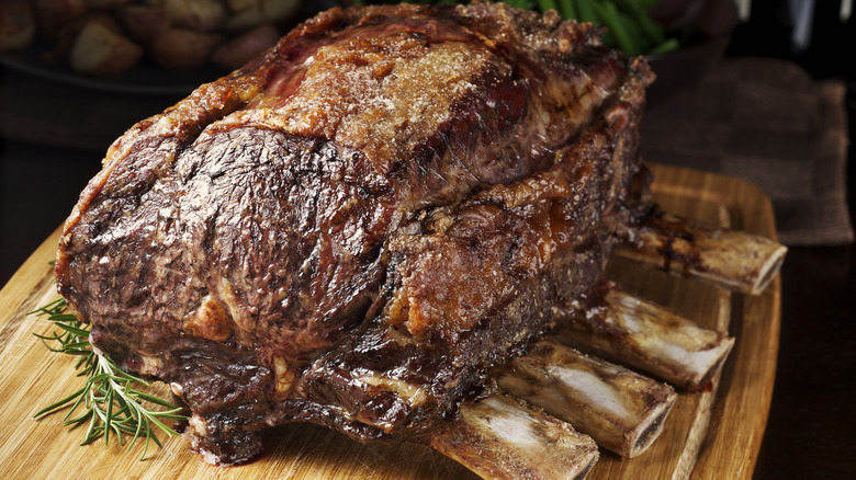 A cooked hunk of meat on a carving board