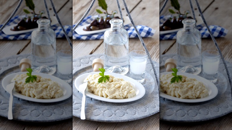 Kalamata olives behind plate of mashed potatoes