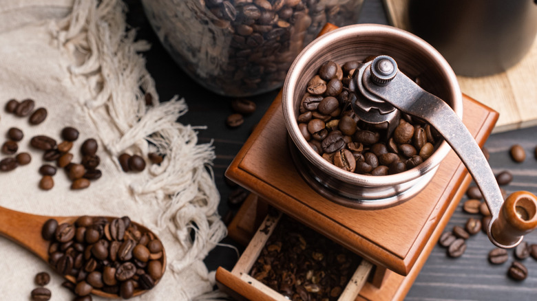 Coffee beans in hand burr grinder