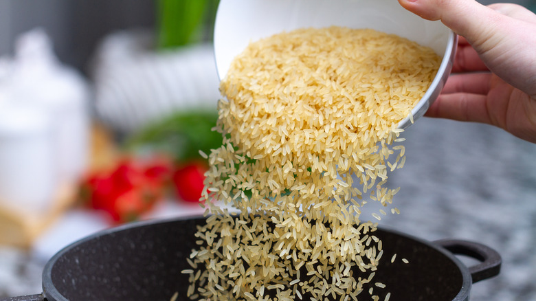 pouring uncooked rice in pot