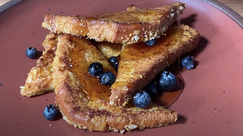 French toast on plate with syrup and blueberries