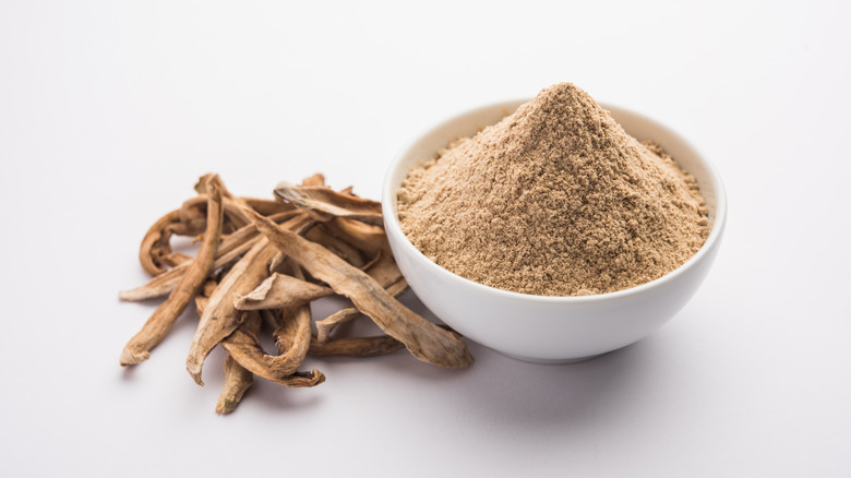 Brown amchur powder white bowl dried mango