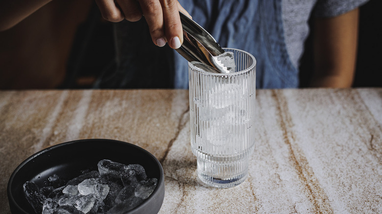 adding ice to tall glass