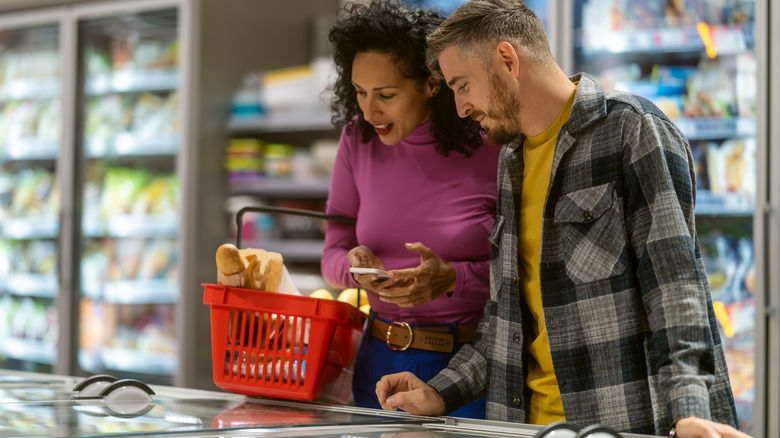 People grocery shopping for frozen food