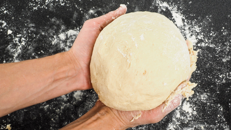 hands holding bread dough