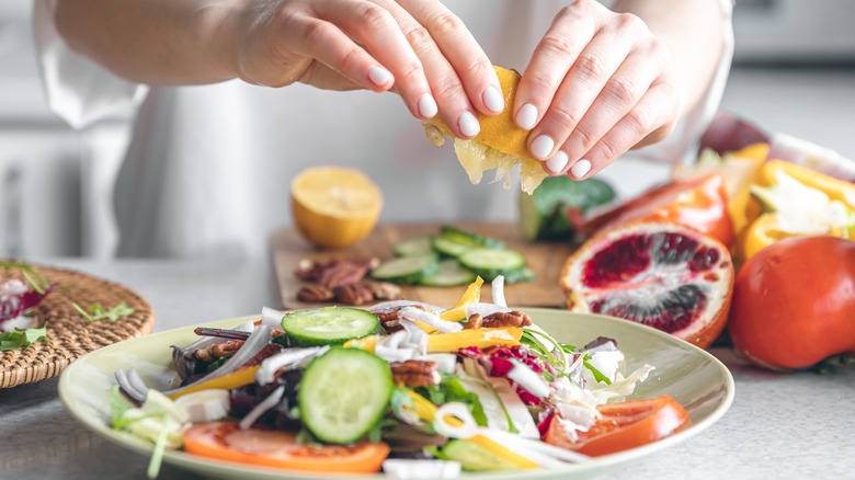 squeezing lemon juice on salad