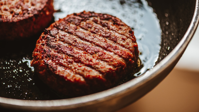 Close up of burger patty in pan 