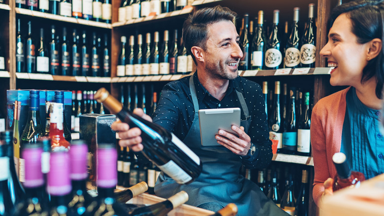 Wine expert helps customer in shop