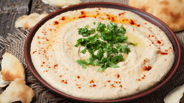 bowl of hummus with parsley garnish