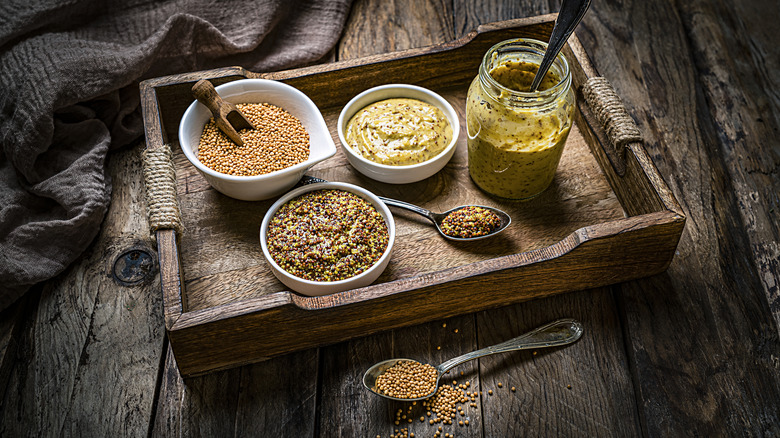 Varieties of mustard on a wooden tray