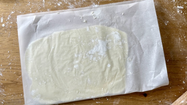 Rolling cream cheese mint dough in parchment