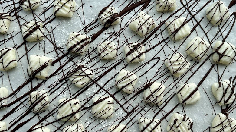 Drizzling cream cheese mints with chocolate