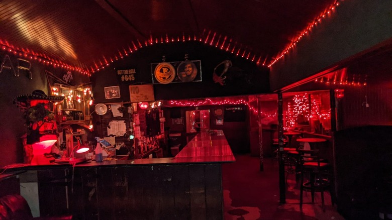 The interior of Snake and Jake's bar lit with red Christmas lights