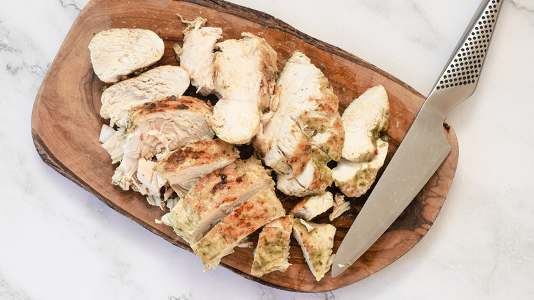 Sliced chicken breasts on cutting board