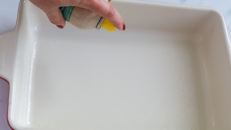 Baking pan being sprayed with nonstick spray