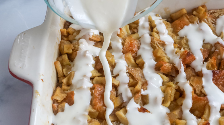 Glaze being drizzled over an apple fritter breakfast casserole