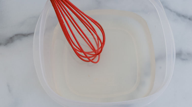 whisking lemon water in bowl