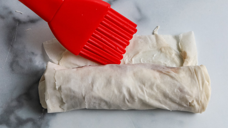 top of phyllo roll  being brushed and sealed