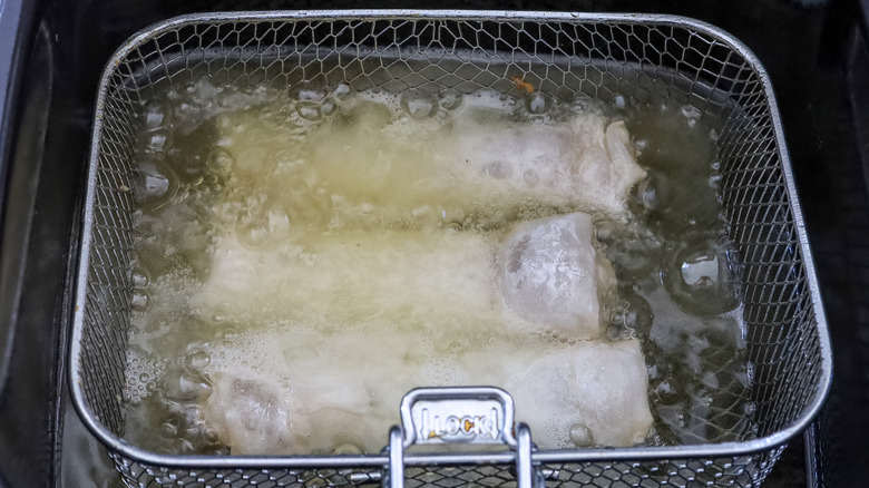 apple pie phyllo rolls being fried in a fryer