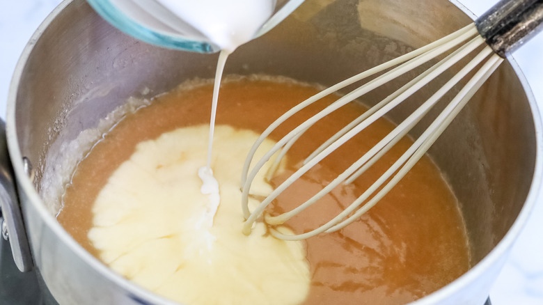 heavy cream being poured into caramel